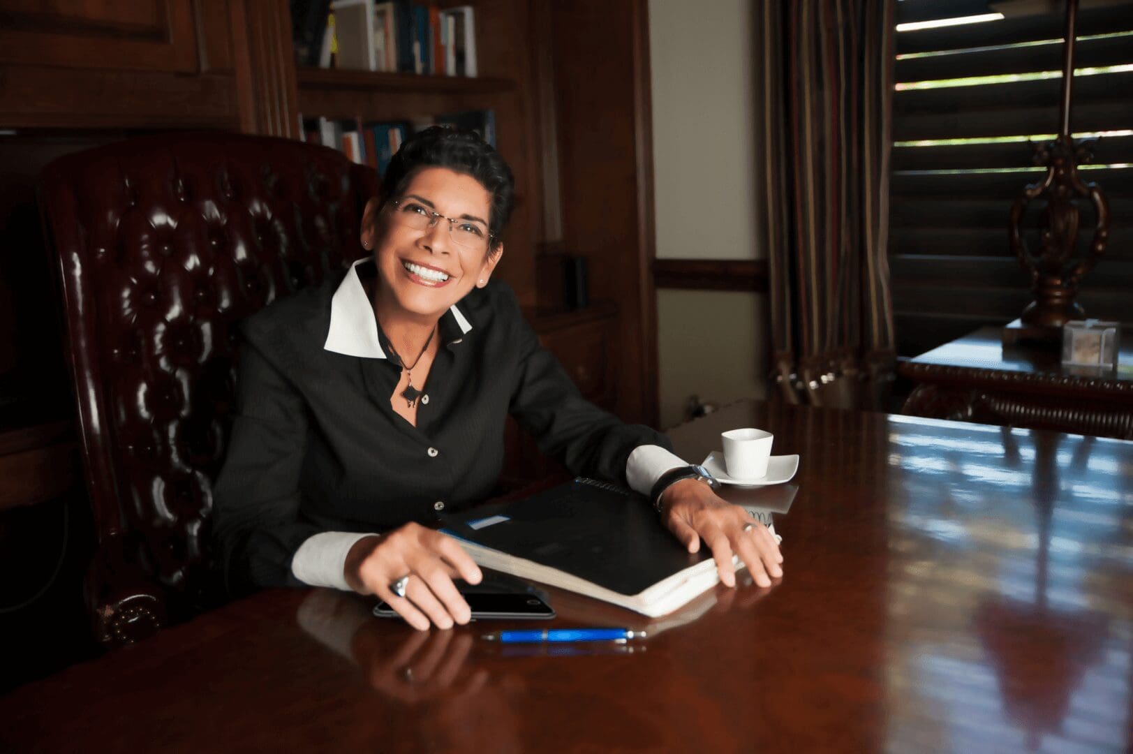 A woman sitting at the table with her laptop.